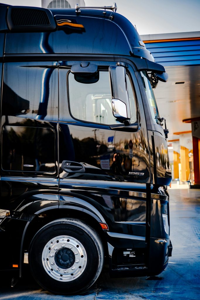 pexels-photo-16100085-16100085 Sleek black truck parked outdoors at a service station during daytime.